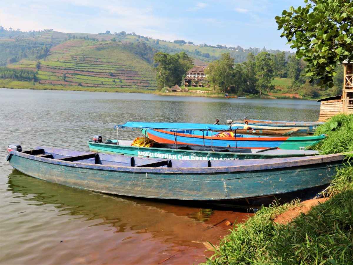 Boats on Lake Bunyonyi with lush green islands and clear blue water, Uganda travel adventure