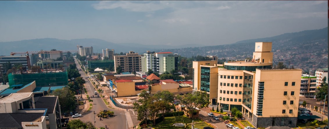 Scenic landscape of Rwanda with rolling green hills, terraced farms, and peaceful rural villages under a clear sky