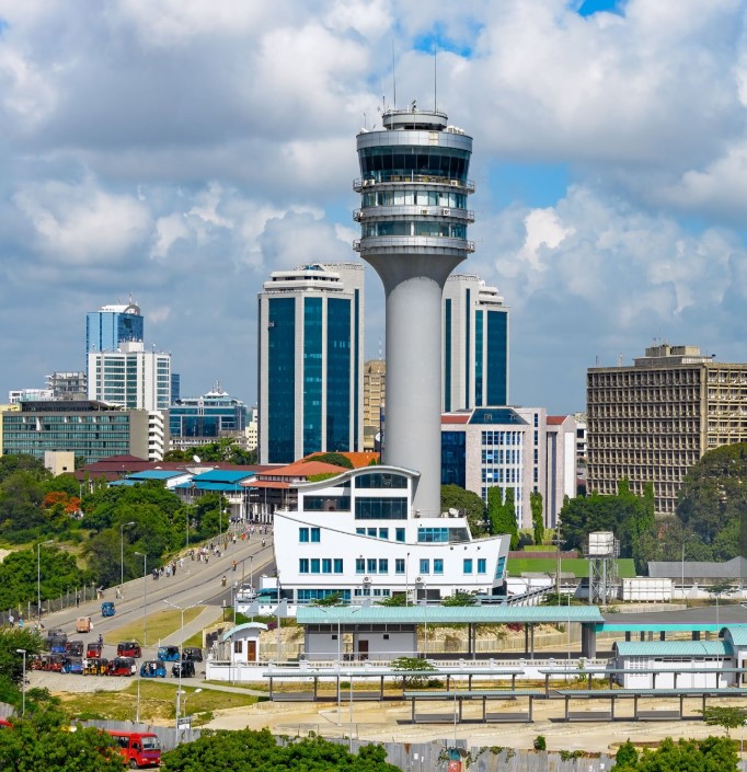 Aerial view of Dar es Salaam city with coastline, modern buildings, and bustling harbor in daylight