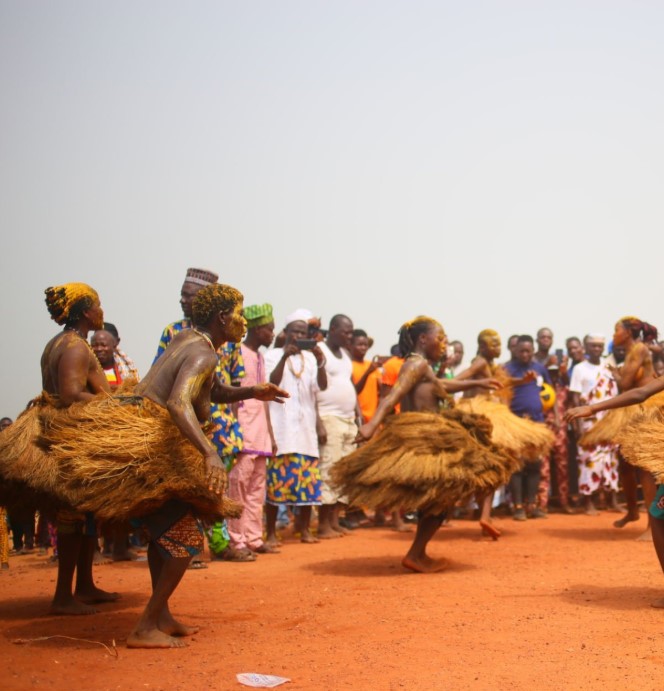 Bakiga performers engaging in a powerful traditional dance with energetic stomping and coordinated movements, dressed in cultural attire.