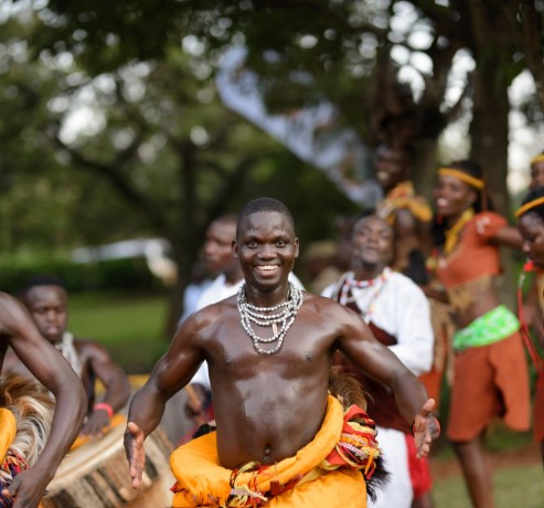 Basoga dancers in traditional attire performing a joyful cultural dance