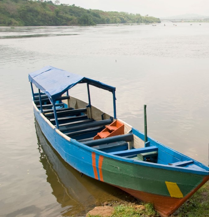 Angler casting a fishing line on Lake Victoria during sunrise, surrounded by calm waters and scenic natural beauty.